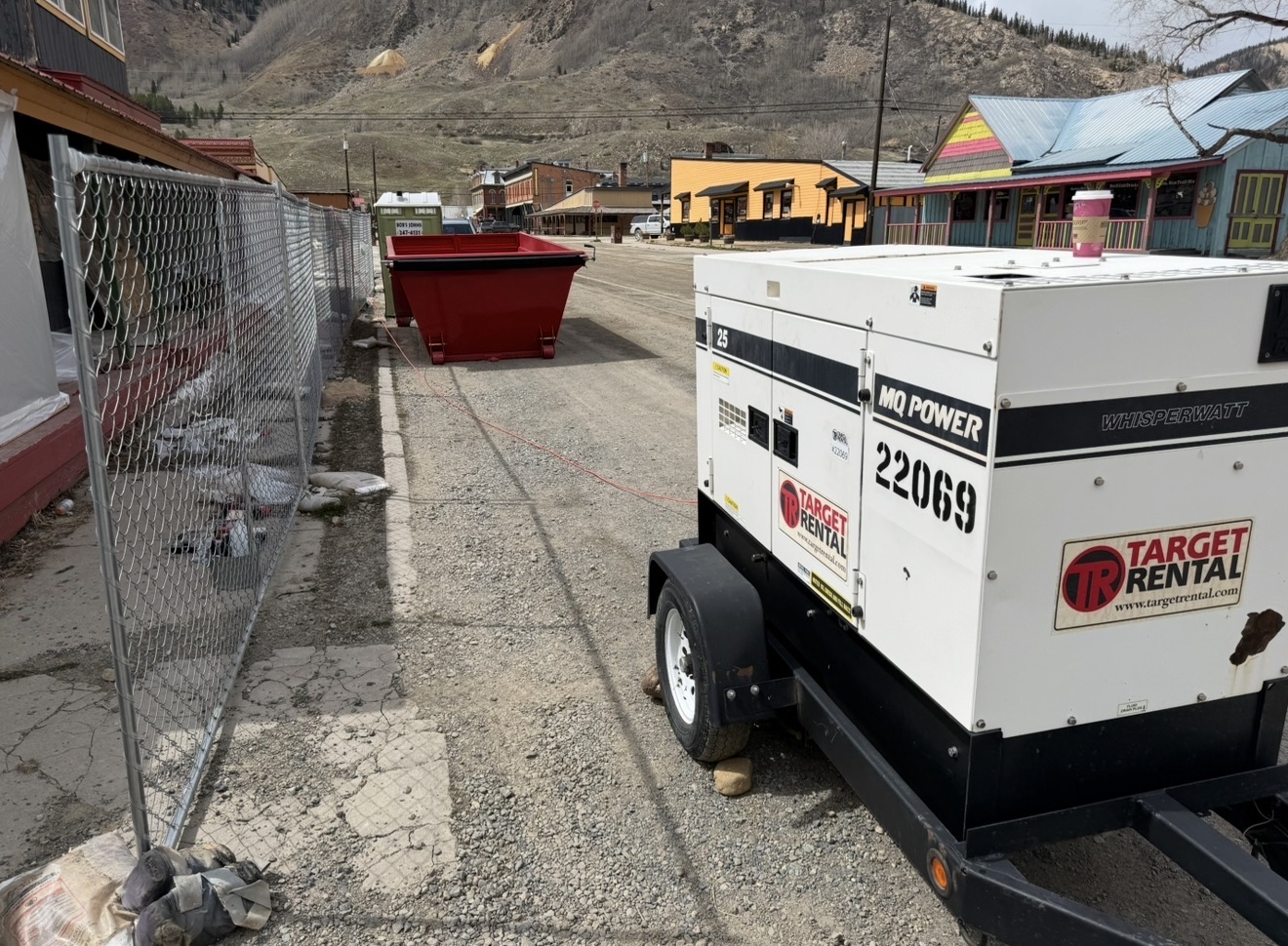 Snow-covered exterior containment enclosure with attached decon chamber on a winter job site