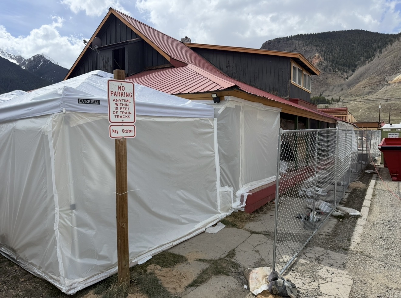 Ram dually pickup with red gooseneck dump trailer parked outside a Durango-area job site