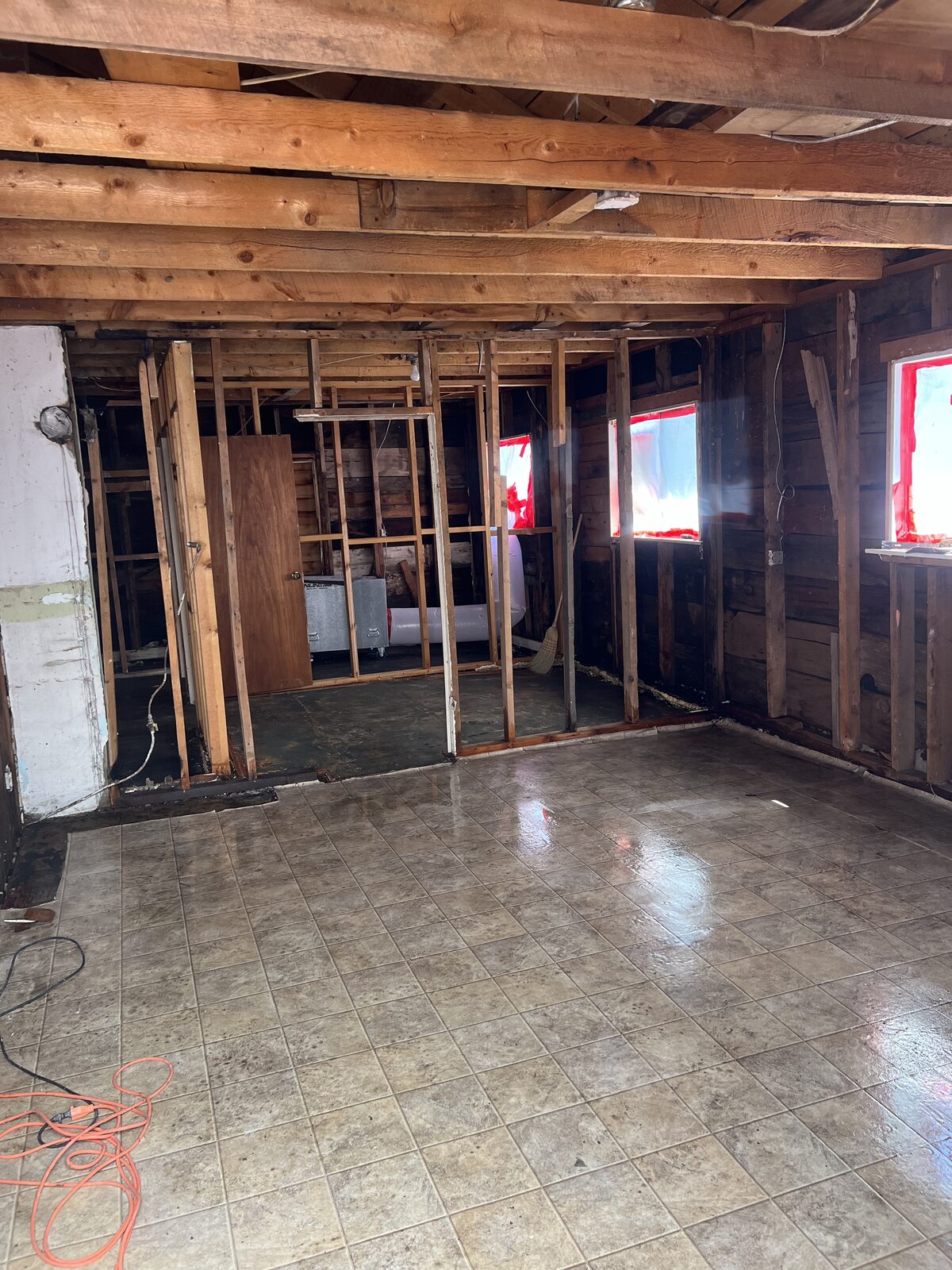 Interior of a residential structure stripped to the studs after asbestos drywall and insulation removal