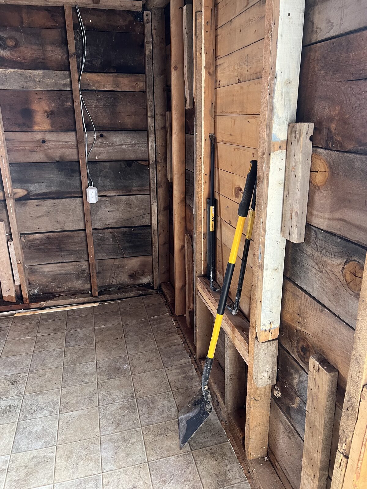 Bathroom interior with old asbestos-containing materials removed, exposing original wood lath and tub