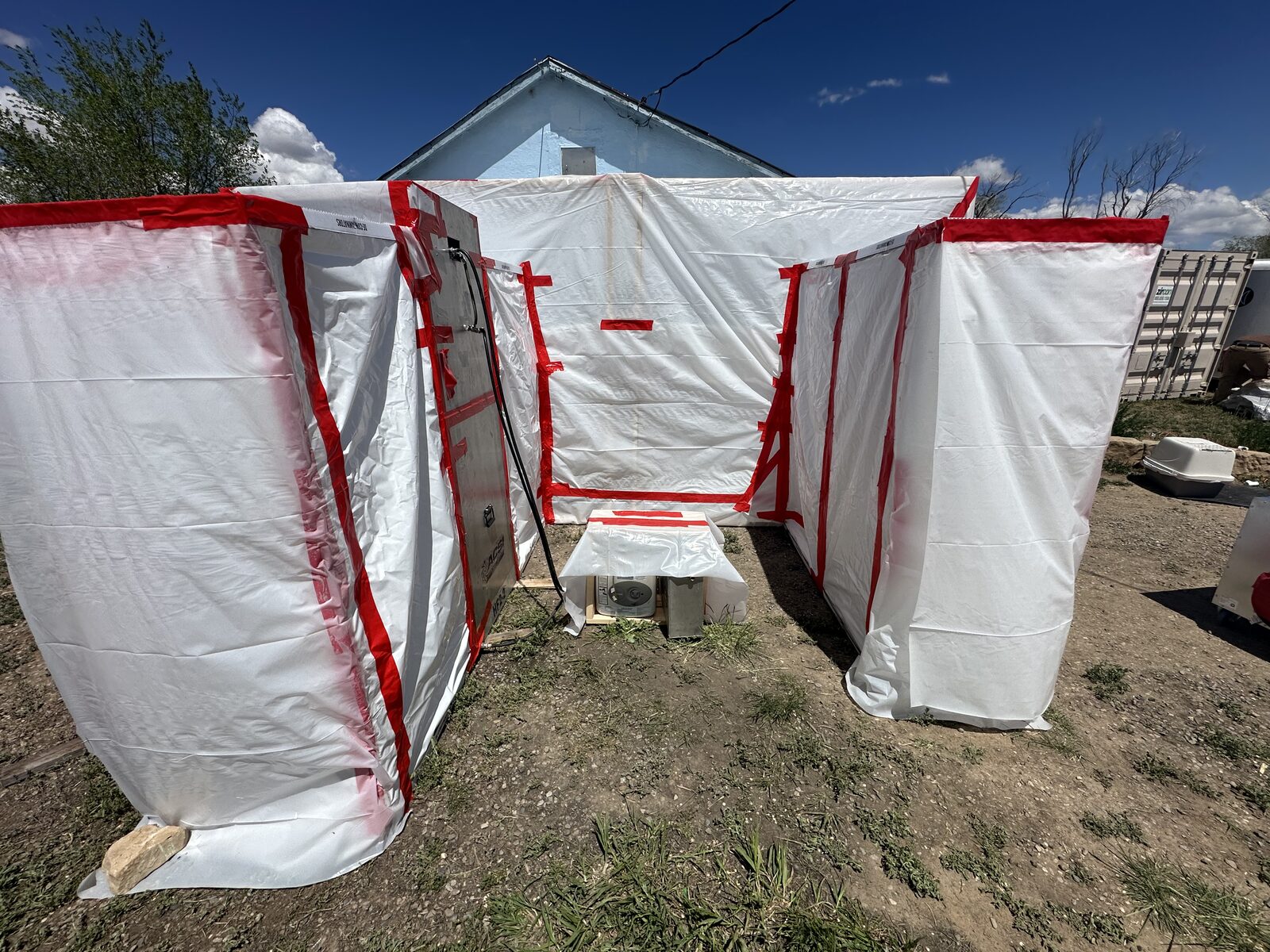 Sealed work-area window covered in red poly during interior asbestos abatement