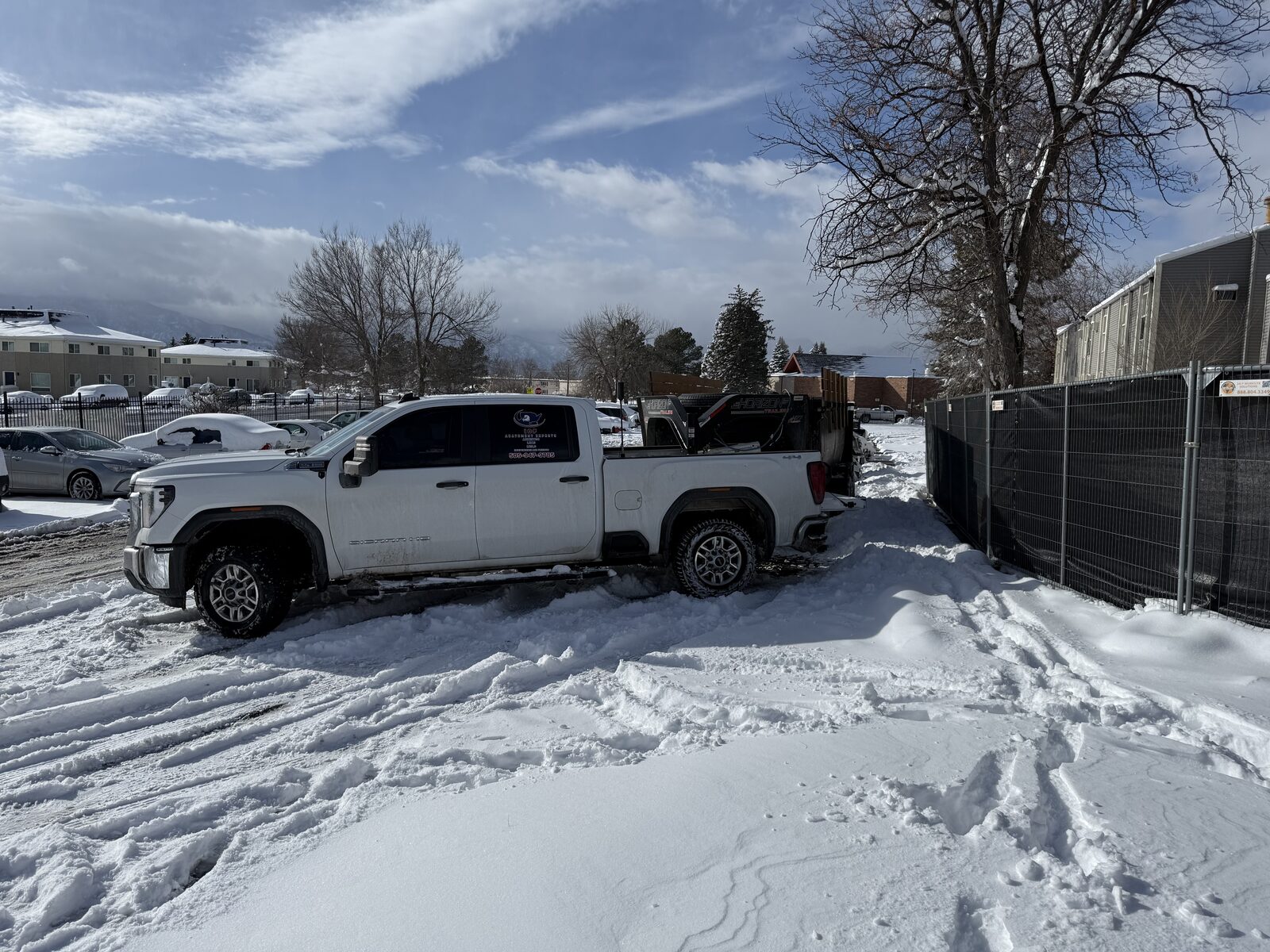 Full asbestos containment enclosure with red barrier tape and posted ASBESTOS warning signage on a Colorado residential exterior